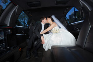 Newlywed,Couple,Kissing,Each,Other,In,Limousine